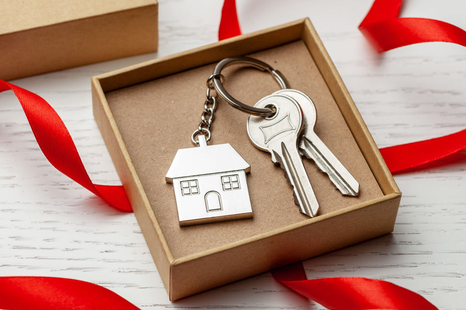 A set of house keys in a box surrounded by ribbon
